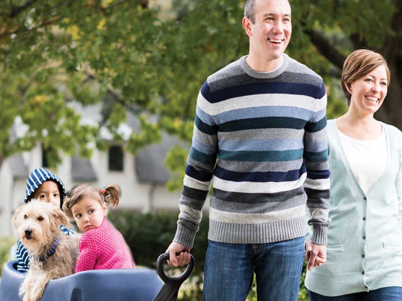 Family walking dog with kids in wagon